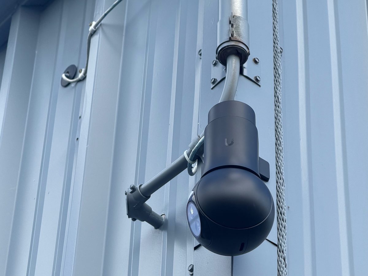 Exterior camera on an arm mount against a metal wall
